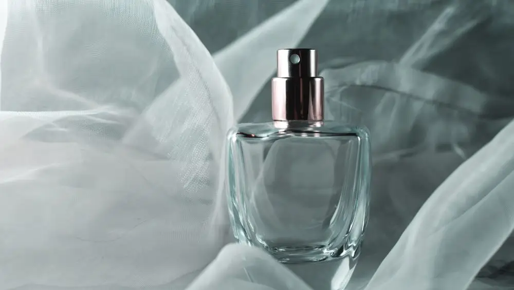 female perfume bottle on blue background