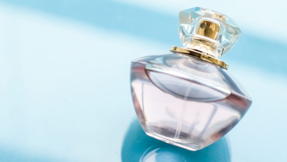 Perfumery, spa and branding concept - Pink perfume bottle on glossy background, sweet floral scent, glamour fragrance and eau de parfum as holiday gift and luxury beauty cosmetics brand design